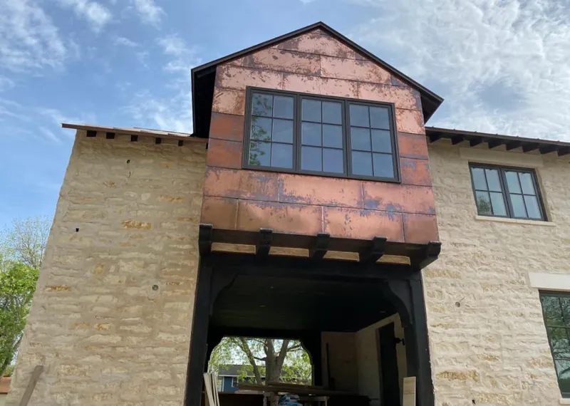 Copper metal panel facade on a stone building for Roof Repair in Irondale